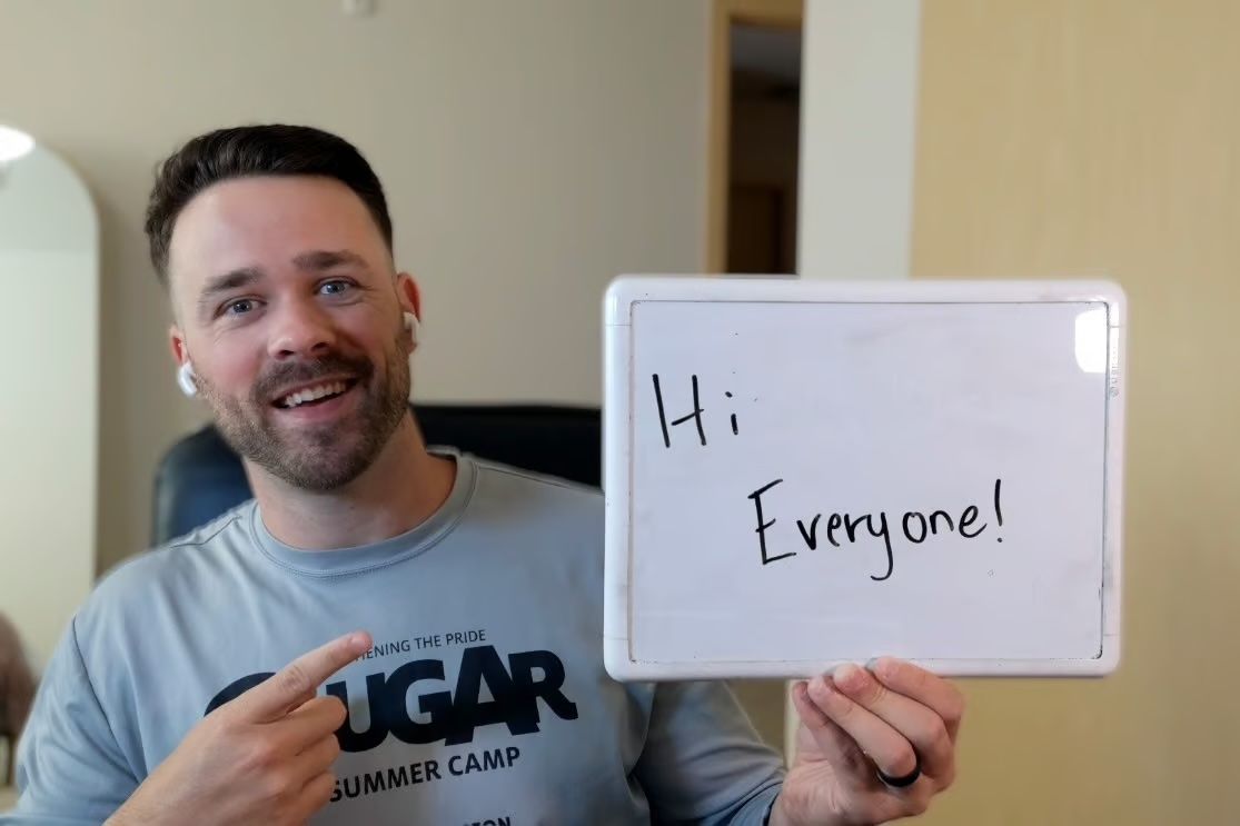 Example of an eye-catching image for cold emails, Troy holding a white board that reads 'Hi Everyone'